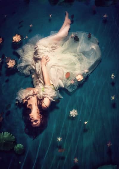 Woman floating in water symbolizing female embodiment practices and sensual healing