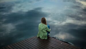 Woman sitting by the water reflecting on the gift of empathy