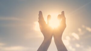 Hands lifted toward the sun, symbolizing spiritual gifts discernment and divine connection