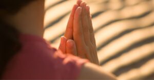 Hands in prayer position during sunset, symbolizing Spiritual Gifts Wisdom