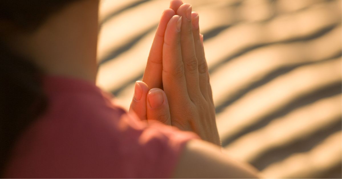 Hands in prayer position during sunset, symbolizing Spiritual Gifts Wisdom