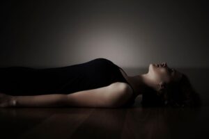 woman lying down but unable to relax during self healing journey and emotional overwhelm