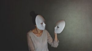 Woman wearing one mask while holding another, illustrating masking in neurodivergent adults