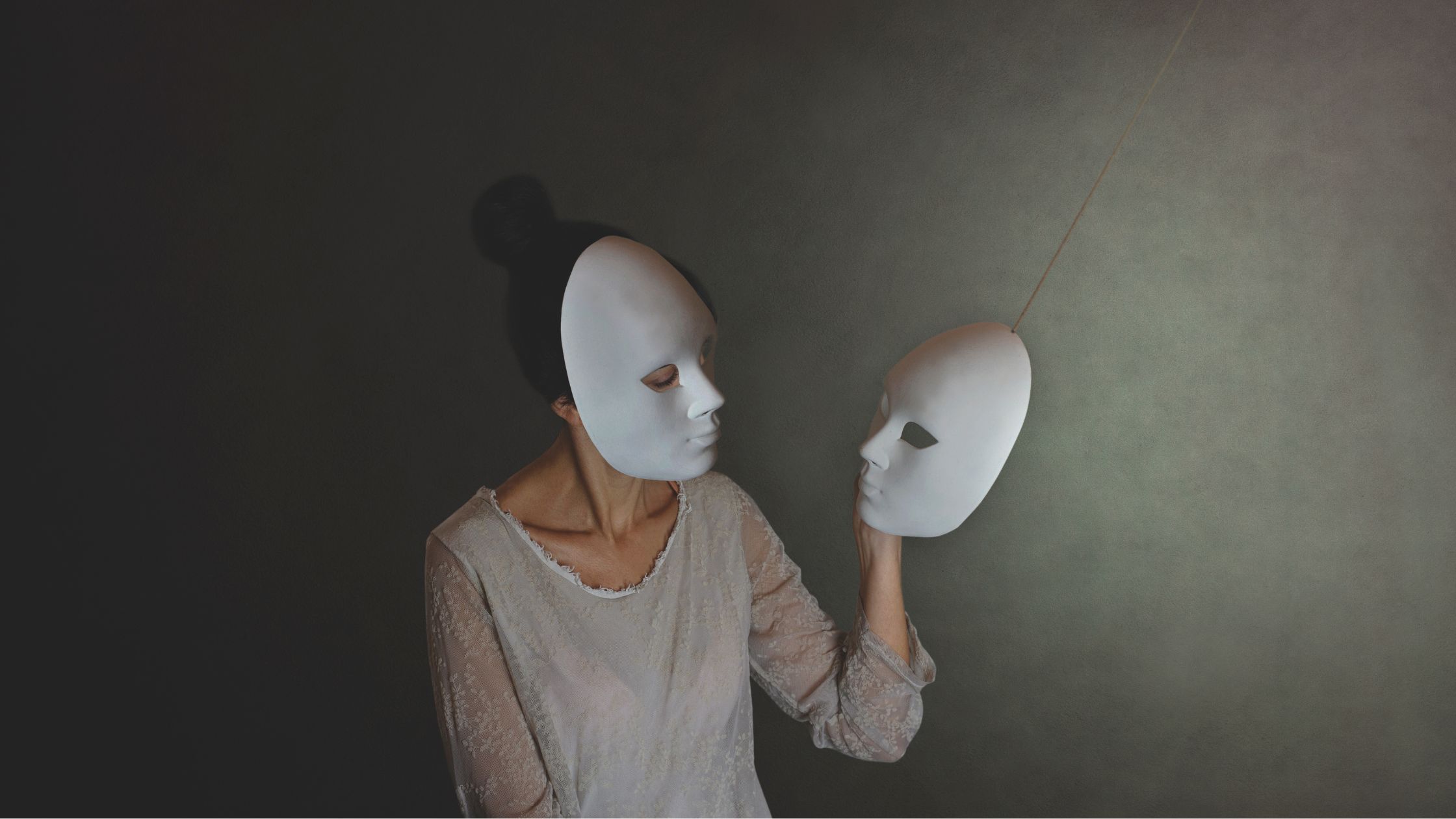 Woman wearing one mask while holding another, illustrating masking in neurodivergent adults